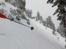 Mostly filled in crown line from a small skier triggered wind slab avalanche about 2 hours before we got there. NE aspect, 39 degree slope, 9100 ft. The crown goes from where I am taking the photo to where my partner is standing.