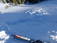 Small ski kick triggered wind slab on the edge of a wind loaded slope in near treeline terrain.